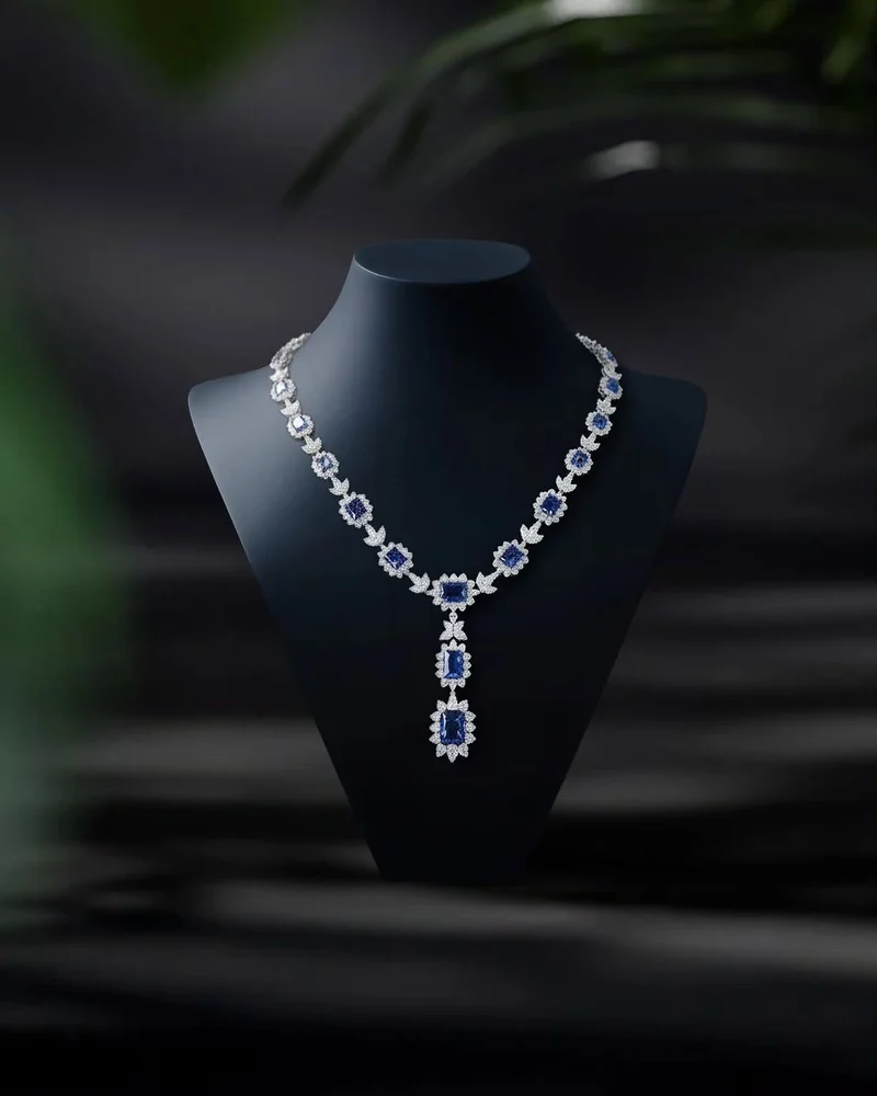 A sapphire and diamond line necklace with a rectangular sapphire pendant.