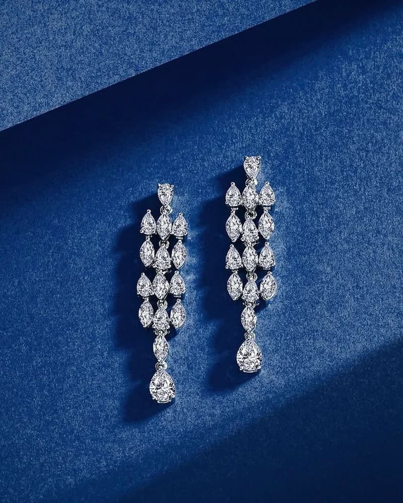 A pair of long diamond line drop earrings ending in pear-cut stones.