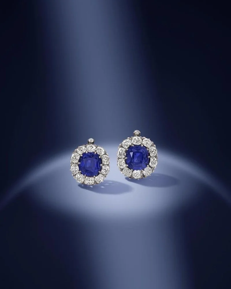 A pair of cushion sapphire studs with full diamond halos.