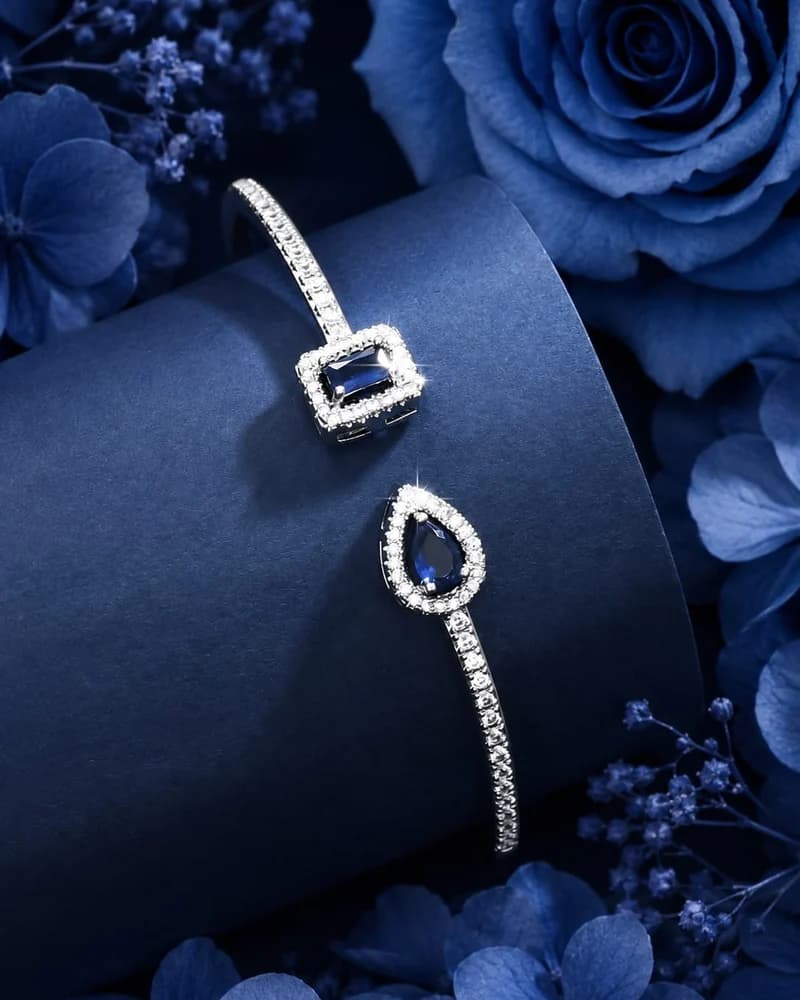 A fine white gold bracelet with an emerald-cut sapphire and a sapphire pear drop.