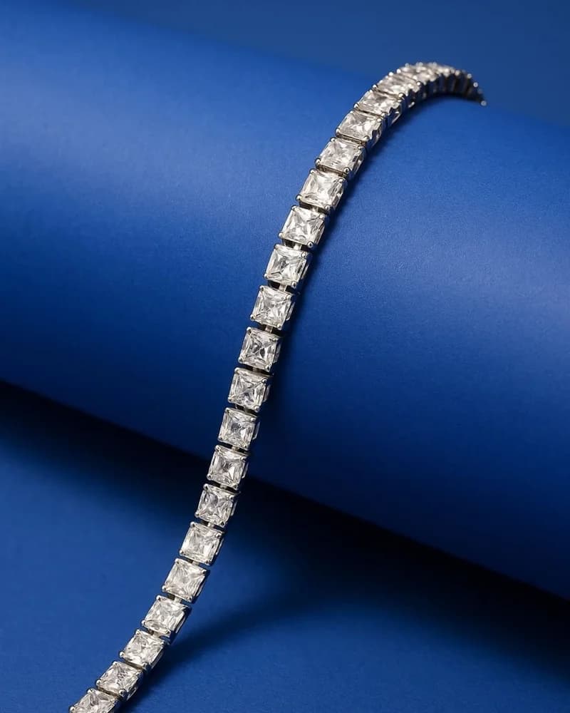 A uniform diamond tennis bracelet curved on deep blue.